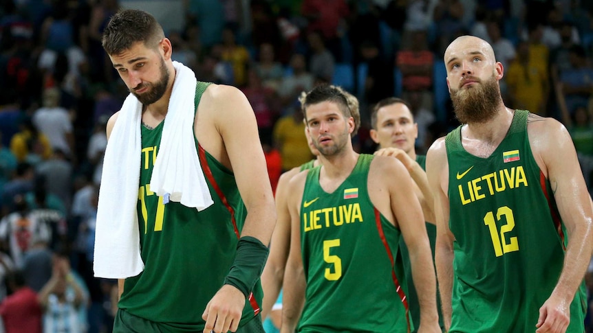 Four basketball players leave the court after their match.