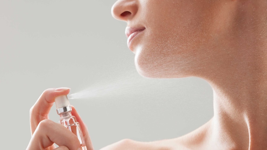 A woman spraying perfume