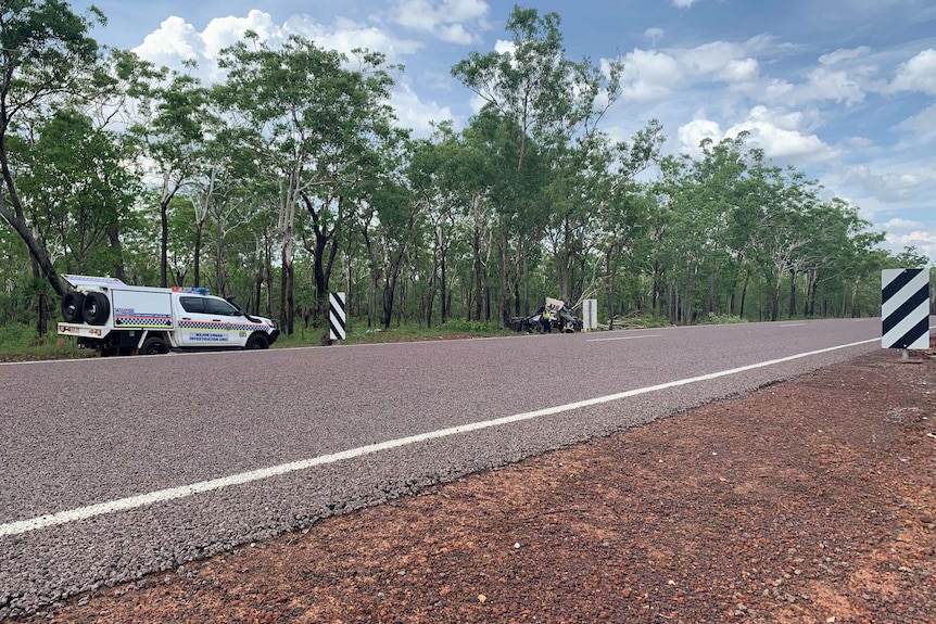 A police car is seen behind a crash site across a single carriageway in Kakadu.