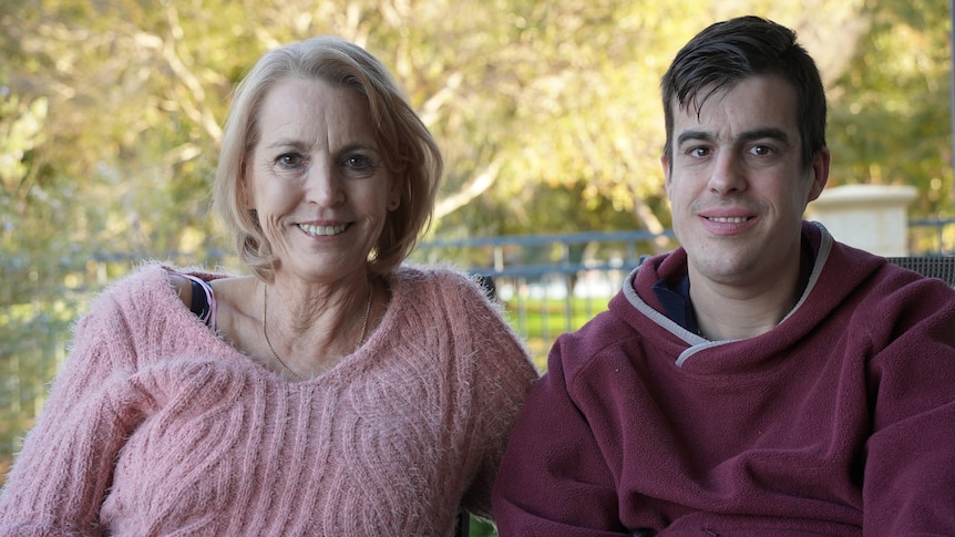 Janette and Ryan sitting together outdoors and smiling.