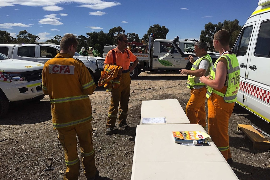 Emergency services workers gather to fight a grassfire