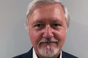 An older caucasian man, in a suit, taking a head profile picture