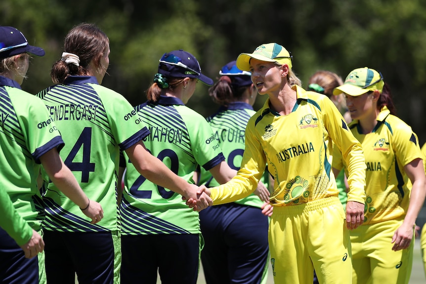 Australia and Ireland captains Meg Lanning and Orla Pendergast shake hands alongside teammates after a T20 cricket match.