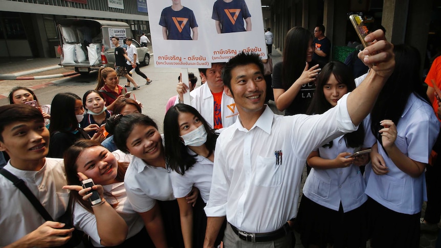 A Thai politician takes a selfie with a group of female supporters