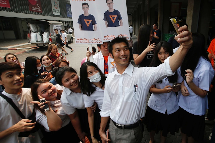 A Thai politician takes a selfie with a group of female supporters