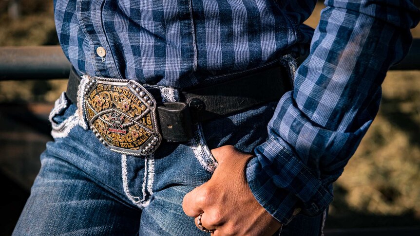 A close-up shot of a trophy buckle Dakota wears on her belt.