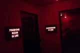 Red lit rooms display signs reading "finishing room in use" and "darkroom in use".