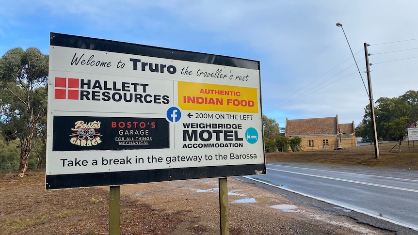 A sign with various business logos on it that says "Welcome to Truro".