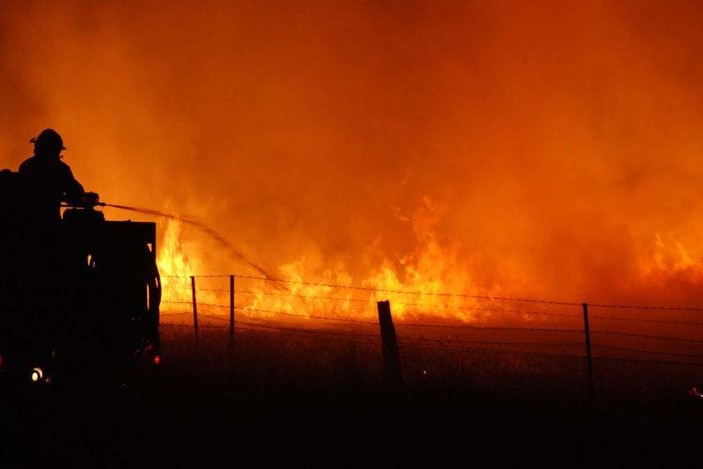 A firefighter with one of the CFA Strike Teams fights a blaze