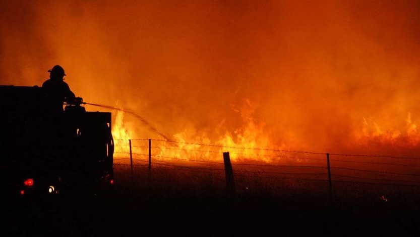 A firefighter with one of the CFA Strike Teams fights a blaze