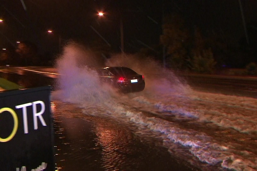 A car drives through flooded roads