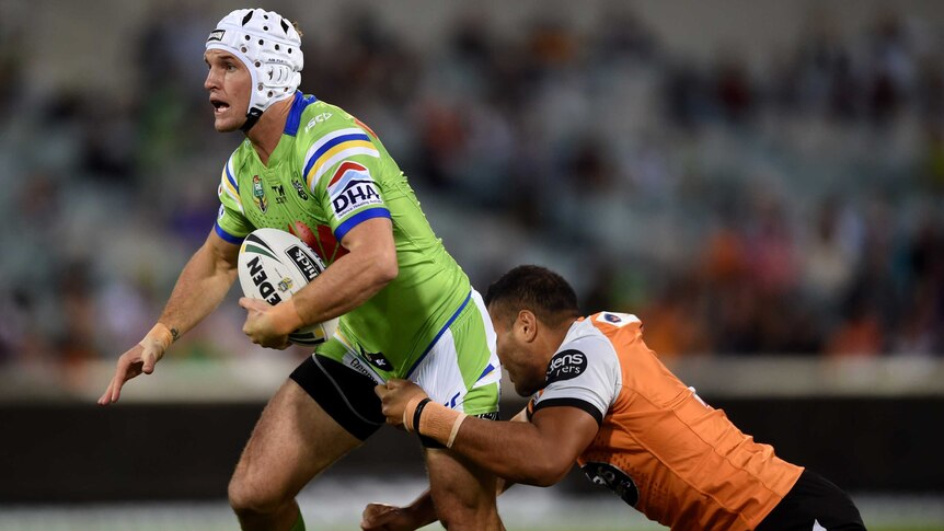 Jarrod Croker of the Raiders busts a Wests Tigers tackle