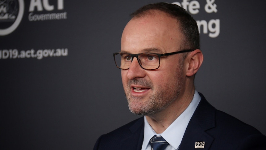 ACT Chief Minister Andrew Barr speaks in front of a podium.