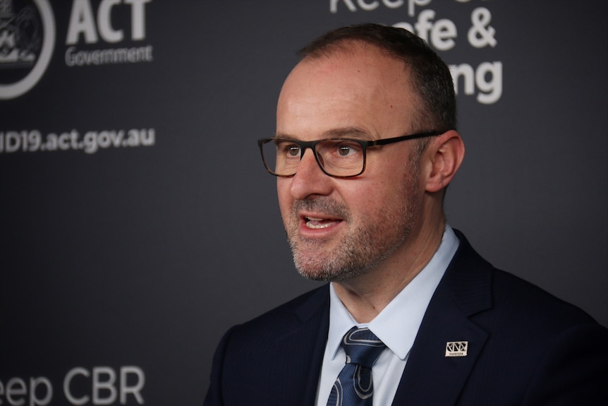 ACT Chief Minister Andrew Barr speaks in front of a podium.