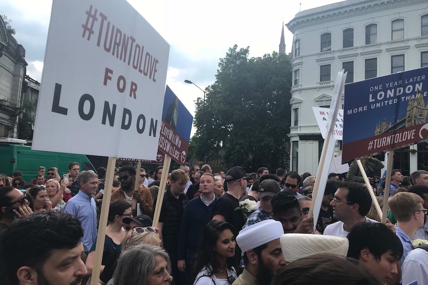 Marchers holding signs at a rally on the anniversary of the London Bridge terror attack.