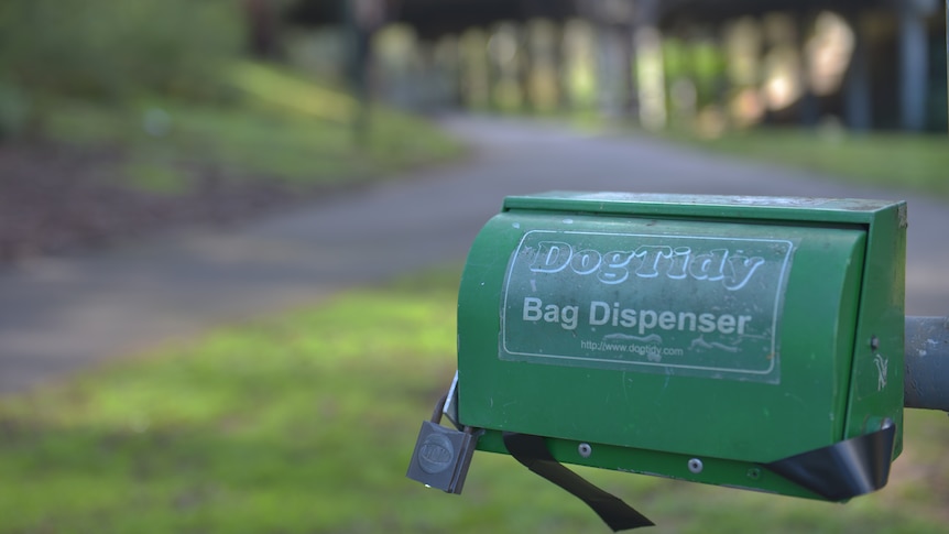 Dog poo bag dispenser in park.