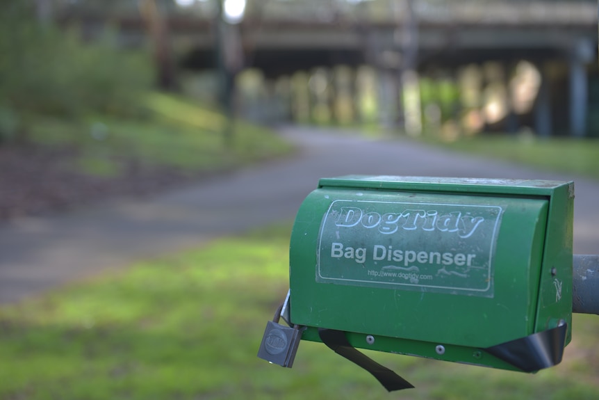 Dog poo bag dispenser in park.