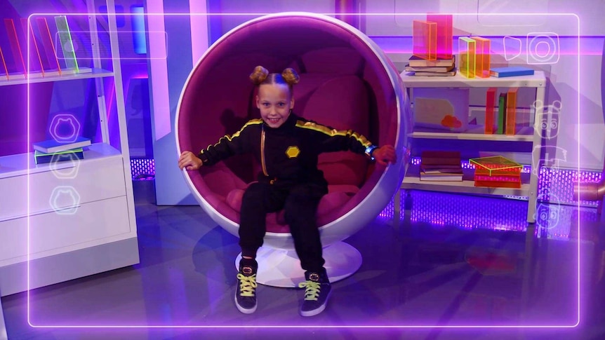 Whyla sitting in a chair on The Wonder Gang set