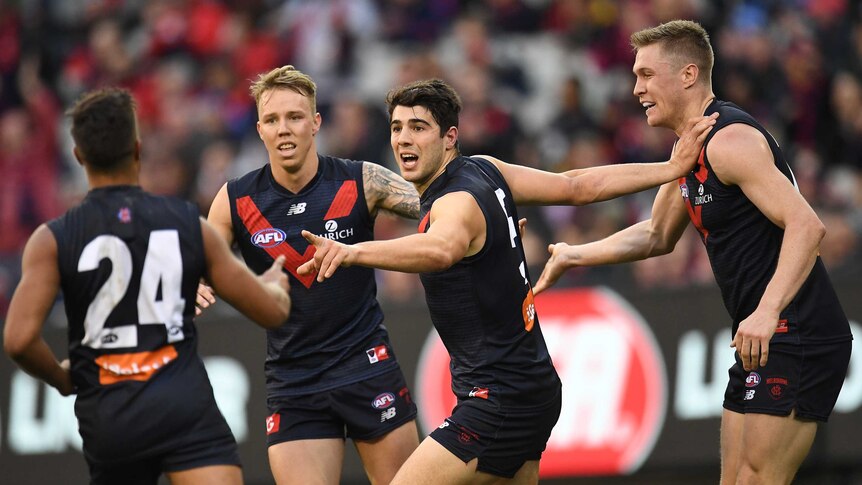 Christian Petracca of the Demons (3L) reacts after kicking a goal against GWS.