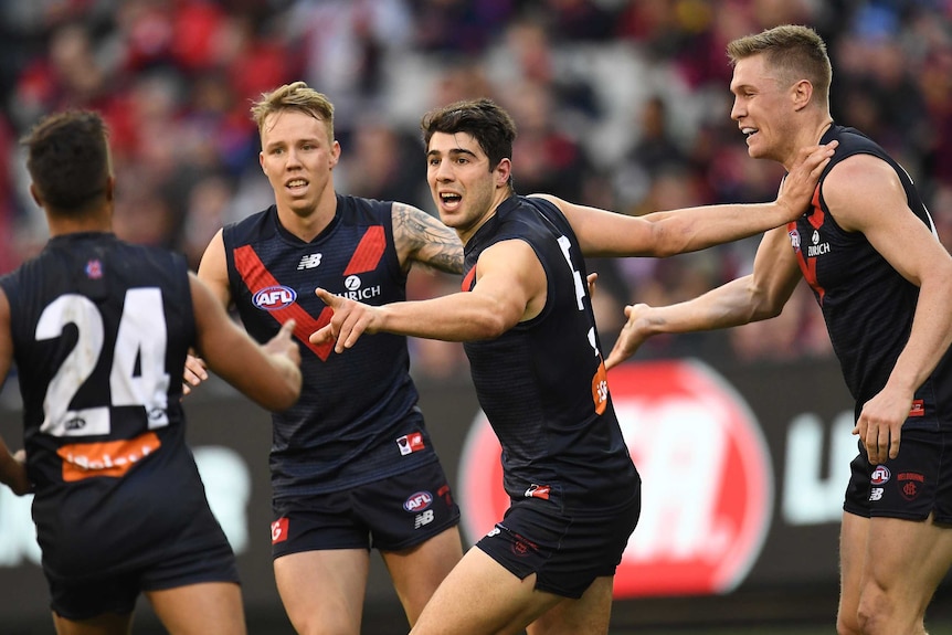 Christian Petracca of the Demons (3L) reacts after kicking a goal against GWS.