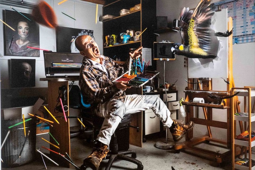 A man surrounded by his artworks flying around the room