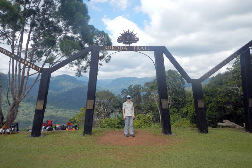 Person standing under a monument gate