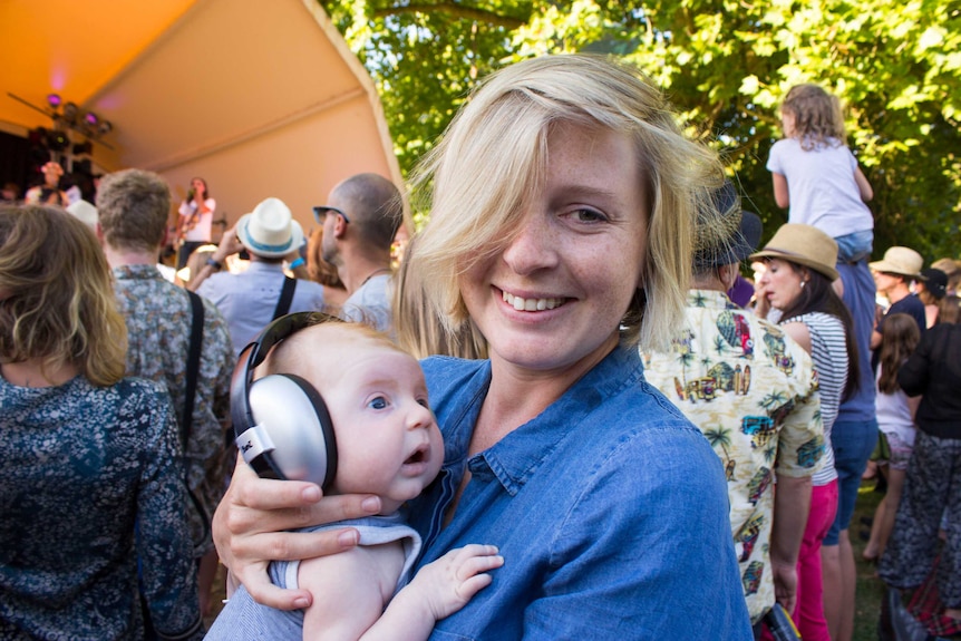 A baby wears headphones to protect its hearing at Summer of Soul.