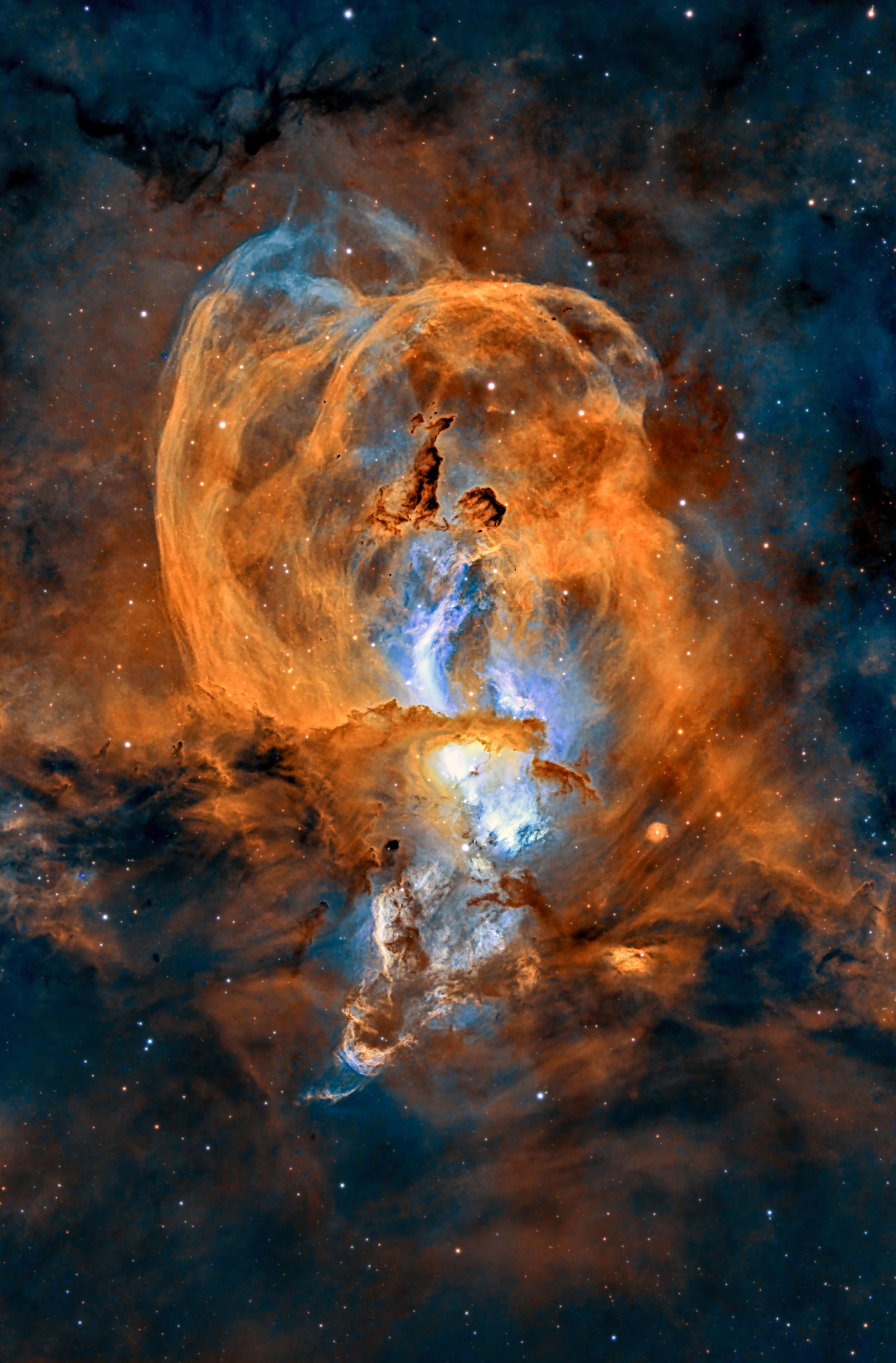 A deep-space photo of a yellow and blue nebula resembling the Statue of Liberty.