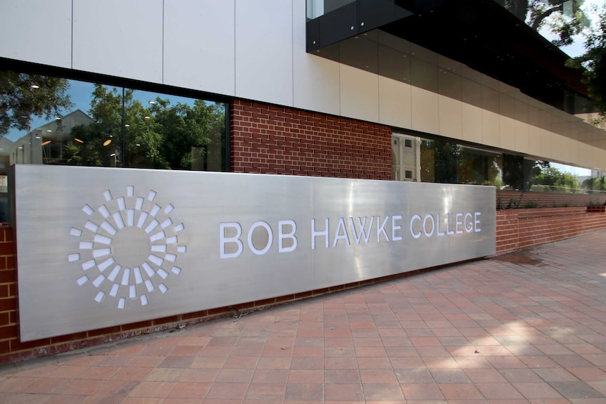 A large metal sign that says 'Bob Hawke College' with a circular motif next to it.