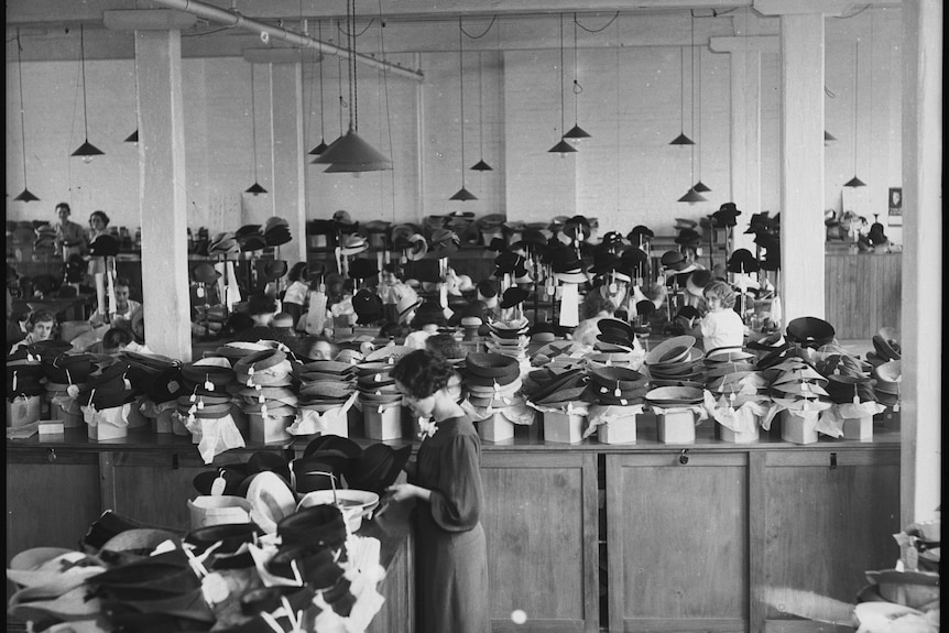 Hundreds of hats are piled around a 1930s hat factory.