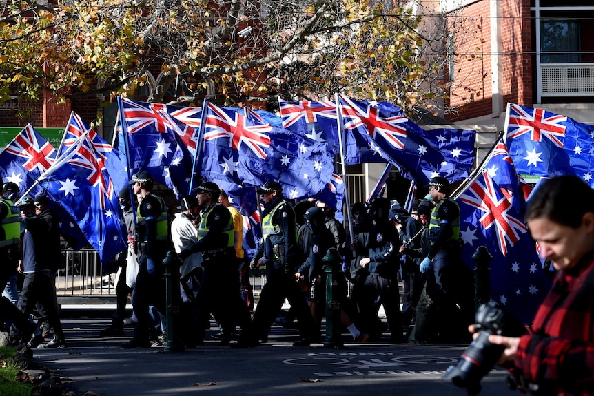 Right-wing protesters from the UPF and the True Blue Crew march to Carlton Gardens with Australian flags.