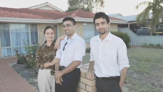 Photo of Akram Azimi with his mother and brother stand out front of a house
