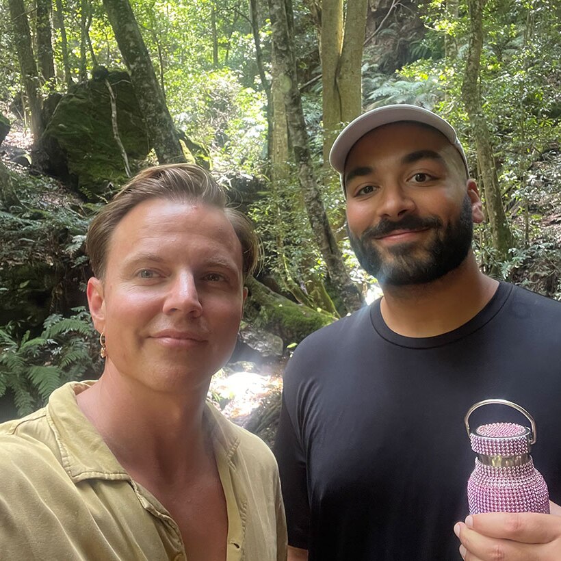 Courtney Act and Alexander Leon standing in a rainforest