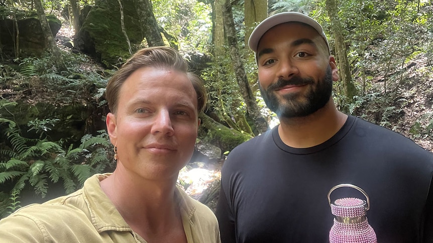 Courtney Act and Alexander Leon standing in a rainforest