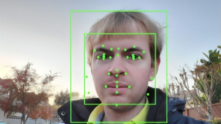 Image of man with facial recognition image superimposed on his face