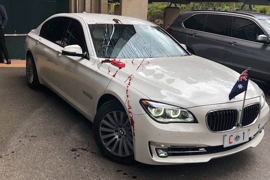 Red tomato sauce or paint splattered on the Prime Minister's car
