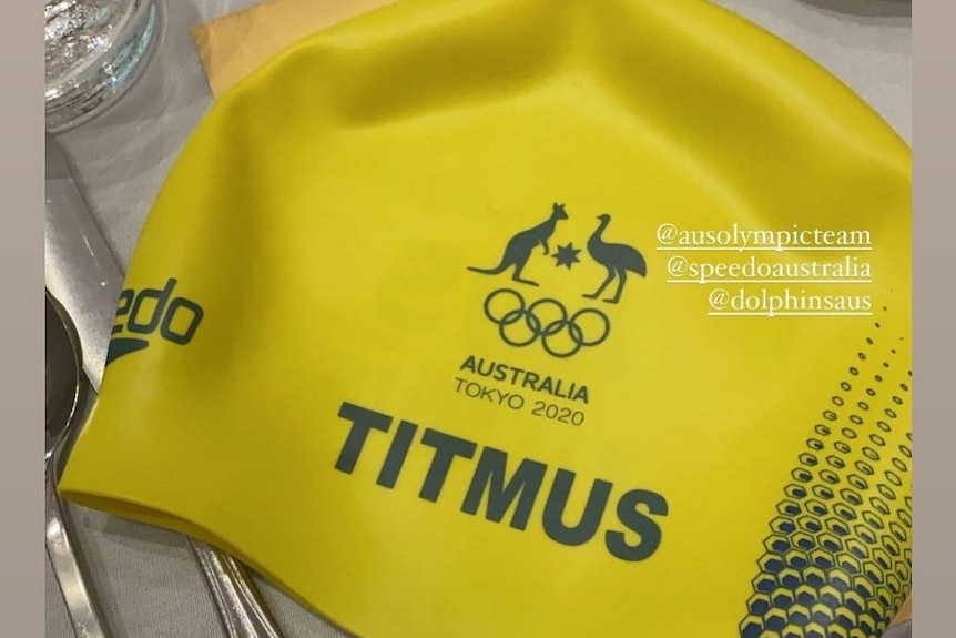 A yellow bathing cap printed with the word Titmus and the Australian national emblem  of a kangaroo and an emu