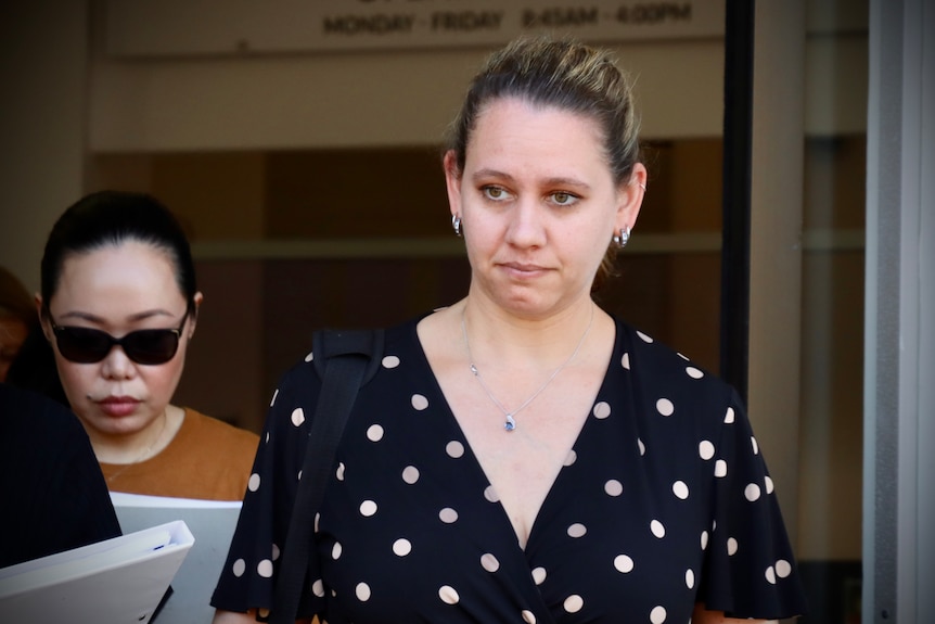 A woman leaving court with a neutral expression