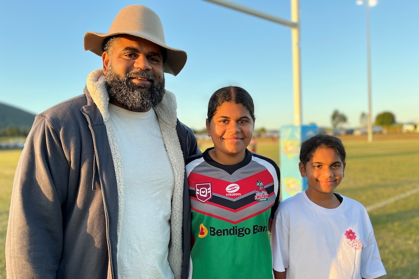 Dad william stands with Lily her her little sister ahead of the under-14s match at Yeppoon, in Queensland. 