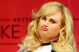Rebel Wilson pouts in front of a red background