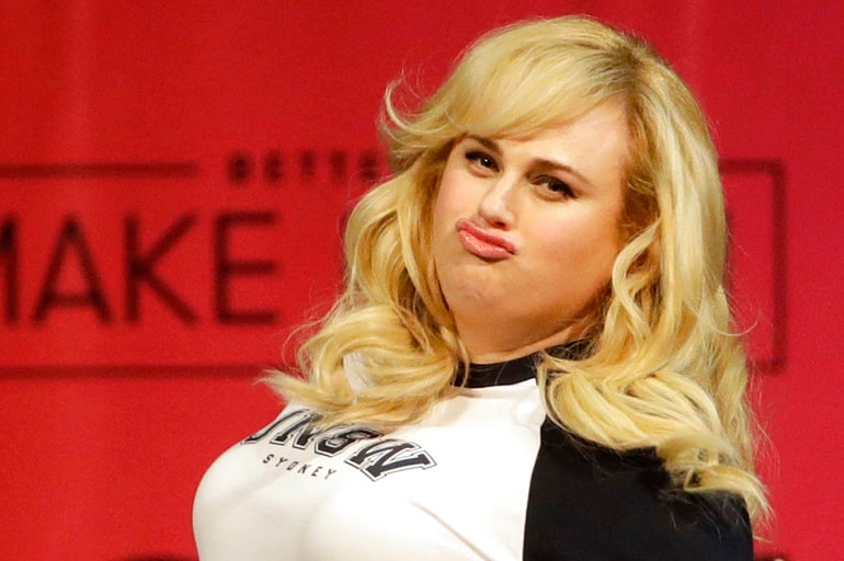 Rebel Wilson pouts in front of a red background