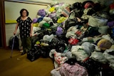 Zions Hill Op Shop manager Susan Clarke in front of large pile of rubbish