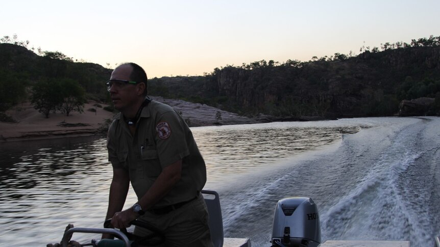 a ranger piloting a boat up the Katherine River