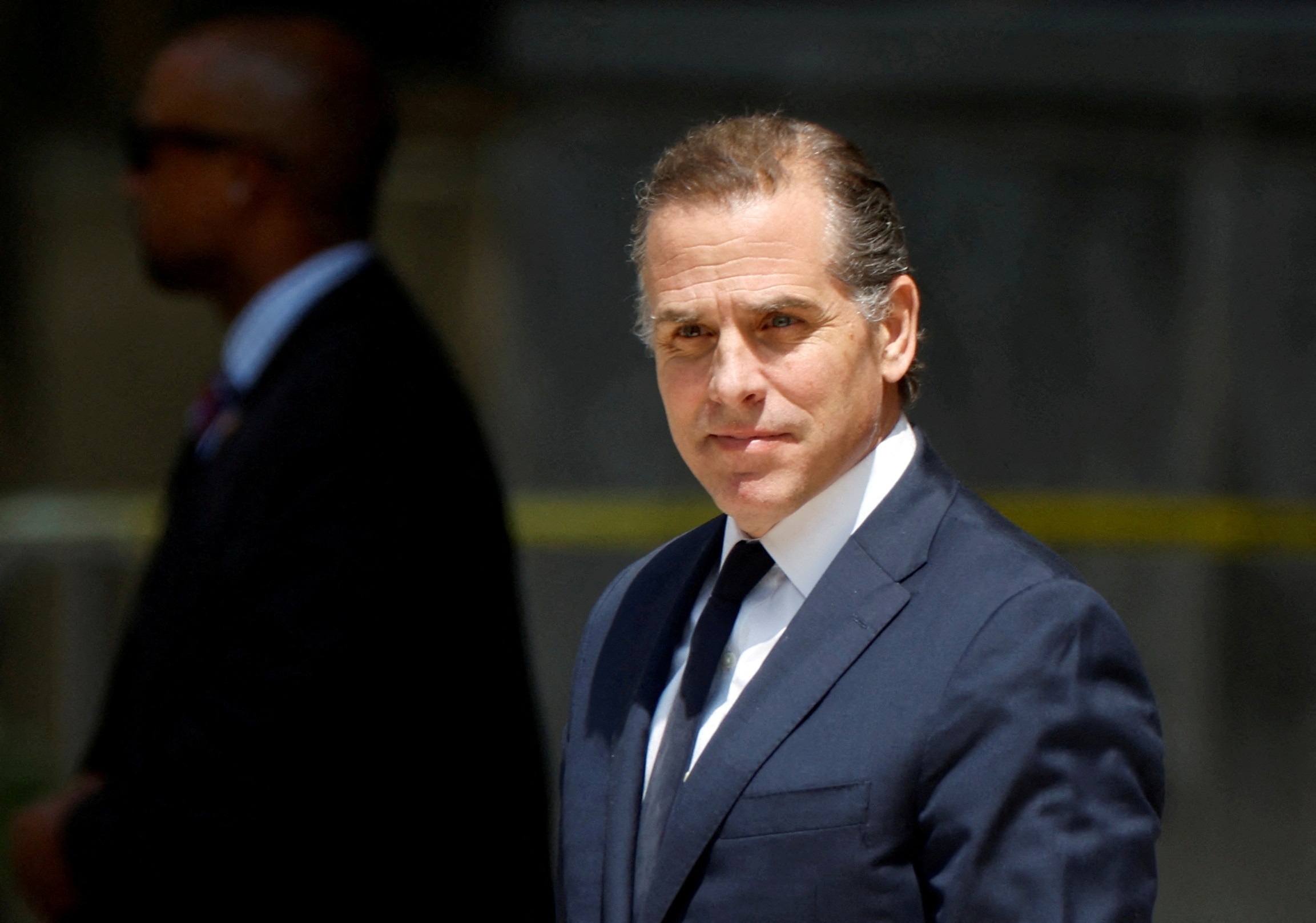 Hunter Biden, dressed in a suit, is seen outside.