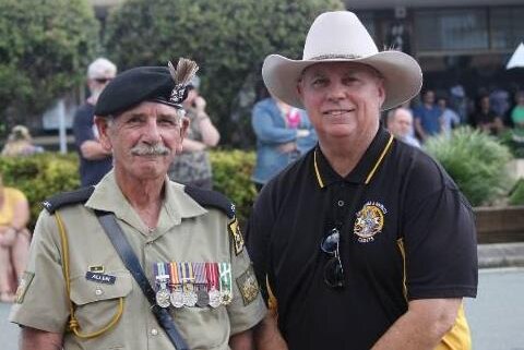A man with his army uniform and medals  and another man in an akubra-style hat