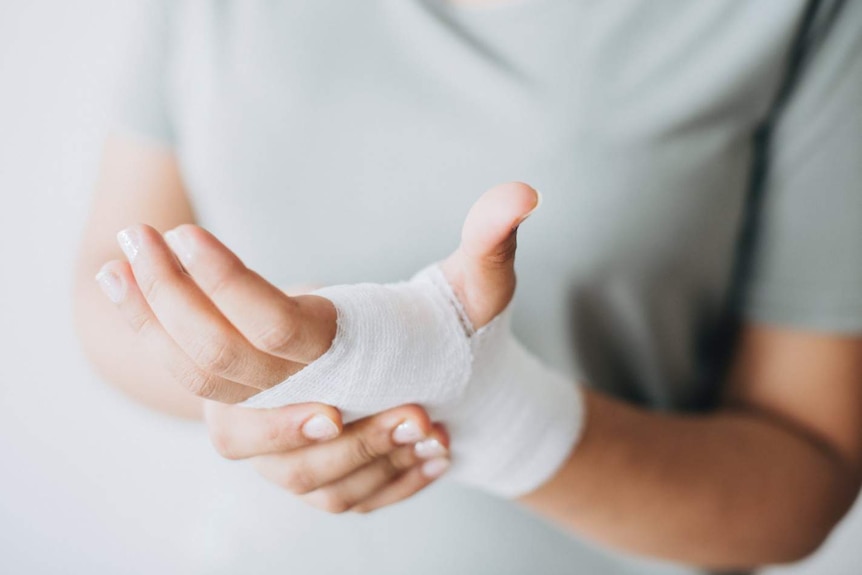 Man with hand wrapped in white bandage.