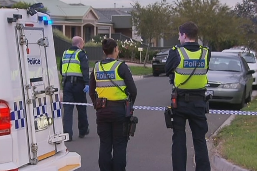 Three police stand on a street where the body of a 49-year-old man was found at Deer Park.