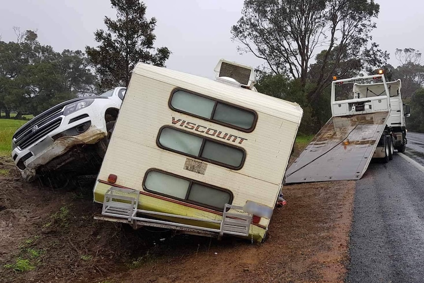A car and caravan destroyed by a crash on the roadside.
