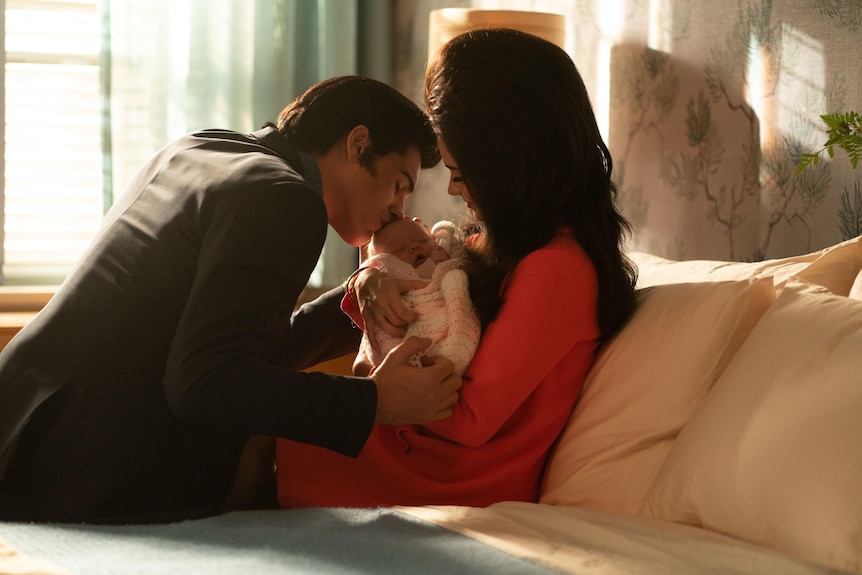 Jacob Elordi as Elvis kisses a baby that Cailee Spaeny as Priscilla cradles in her arms in a scene from Priscilla.