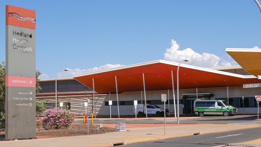 A hospital in Hedland with an ambulance and police car parked outside.